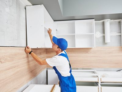 kitchen installation. Worker assembling furniture